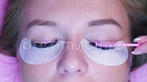 女人的脸美容师梳理睫毛视频的预览图