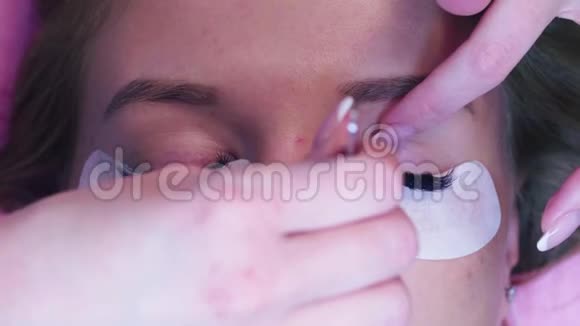 女人的脸美容师梳理睫毛视频的预览图