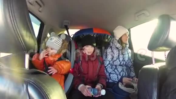 家人坐在车里太阳透过玻璃的光线慢动作视频的预览图