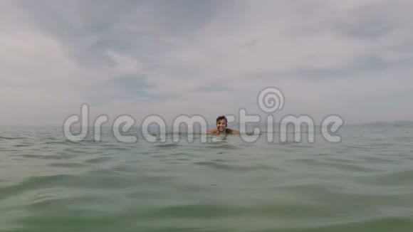 西班牙裔男子在美丽的海滩上游泳动作镜头拍摄年轻人的照片视频的预览图