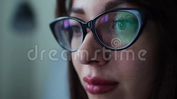 戴眼镜的女人看着平板电脑上网视频的预览图