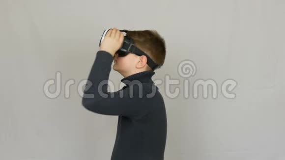青少年男孩看白色虚拟现实眼镜或虚拟现实并在工作室的白色背景上玩得很开心未来是视频的预览图