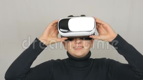 青少年男孩看白色虚拟现实眼镜或虚拟现实并在工作室的白色背景上玩得很开心未来是视频的预览图