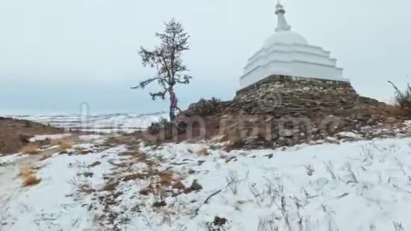 贝加尔湖冰上女子旅行波夫的观点佛教佛塔伯汗纪念塔象征神秘历史视频的预览图