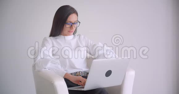 戴着眼镜坐在扶手椅上的年轻白种人女商人的特写镜头视频的预览图