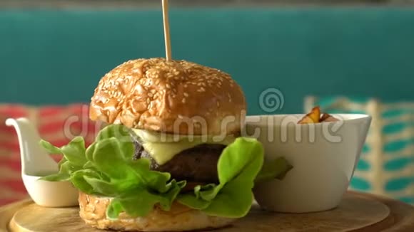 在木制托盘上旋转自制汉堡和炸土豆酱视频的预览图