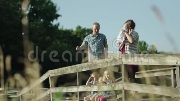 有四个孩子的幸福家庭在公园桥上全高清视频的预览图
