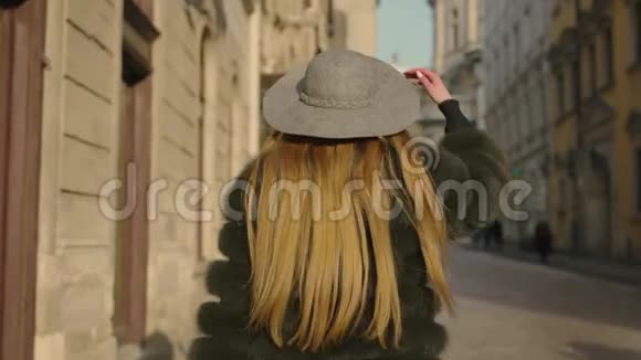 一位留着长发的年轻女子一双灰色的蓝色大眼睛正在市中心疾驰而来而不是转向相机和微笑视频的预览图