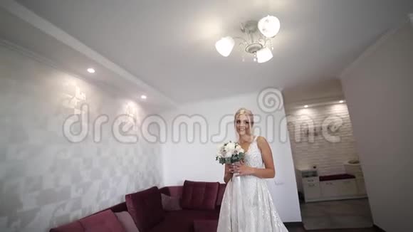 优雅的新娘手里拿着一束婚礼花束漂亮的金发女孩有时尚的妆容和发型妇女模式视频的预览图