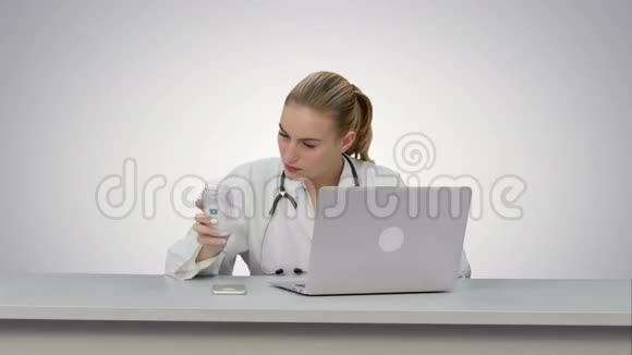 一位护士在白色背景下用笔记本电脑研究新药丸的肖像视频的预览图