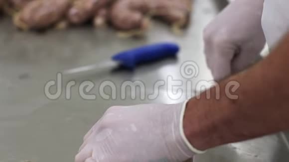 肉类工厂的工作男工把肉和网绑在一起香肠制作过程视频的预览图