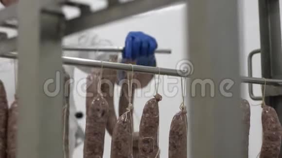 男工在架子上分发香肠肉类加工工厂工艺视频的预览图