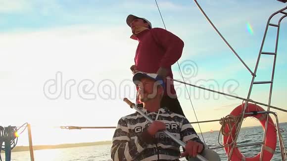 年轻的水手和帆船上的高级船长团队合作帮助视频的预览图