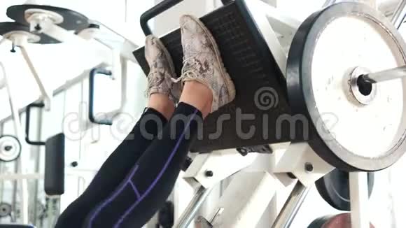 女性腿部训练在健身房的机器压力视频的预览图