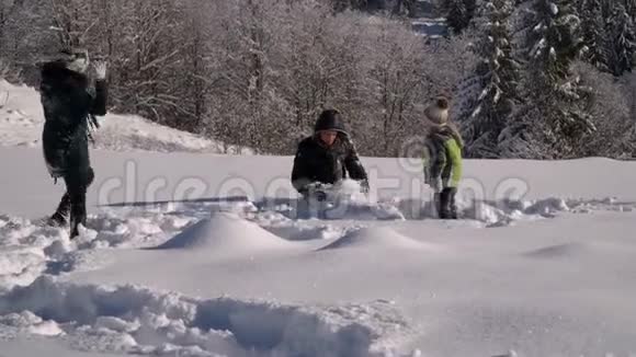 快乐的年轻家庭正在雪地里玩得很开心他们扔雪和笑他们也快乐地掉进了雪里视频的预览图