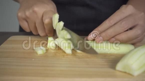 慢动作关闭首席女性制作沙拉健康食品并在厨房的砧板上切黄瓜视频的预览图