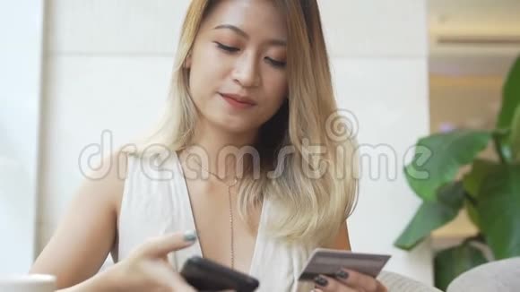 女人用智能手机和信用卡在网上买新衣服视频的预览图