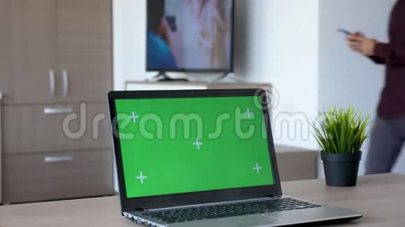 客厅书桌上带有独立模拟绿色屏幕的笔记本电脑视频的预览图