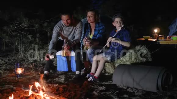 周末在森林的家庭旅行美国家庭在林地的旅行营父母喝啤酒孩子吃zephy视频的预览图