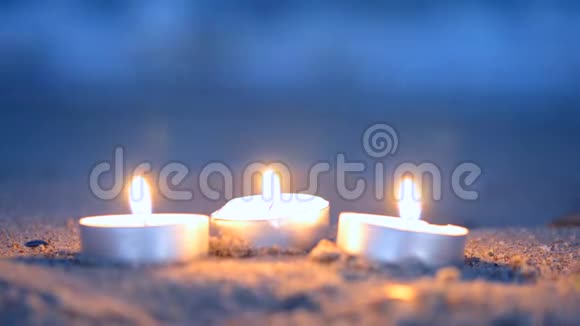 三个小烛台躺在波浪附近的沙滩上视频的预览图