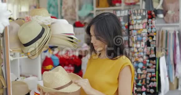 在店里试帽子的迷人模特视频的预览图