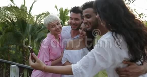 青少年在手机上自画像拥抱户外快乐微笑的朋友在夏日的露台上视频的预览图