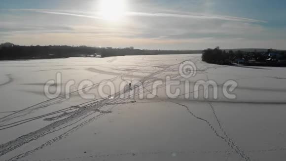 渔夫走在结冰的河上从上往下看雪中行走的人的影子空中观景4K视频的预览图