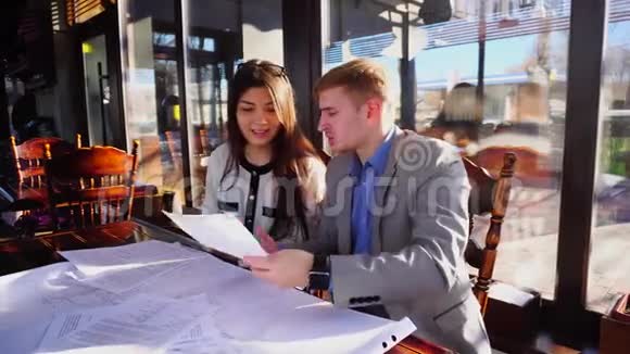 学生们在咖啡馆的桌子上争论建筑家庭任务草案视频的预览图