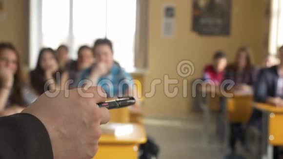老师带着一群高中生在教室里从老师的手中看讲座视频的预览图