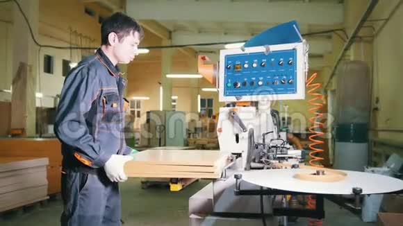 工人木工处理家具厂边缘机器上的木板视频的预览图