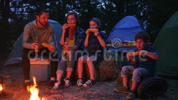 女人和男人在暑假里喝啤酒吃新鲜的黄玉米一家人在吃玉米视频的预览图