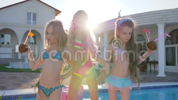 在泳池附近疯狂的儿童舞蹈暑假的儿童名人带着背光鸡尾酒的富家子弟视频的预览图