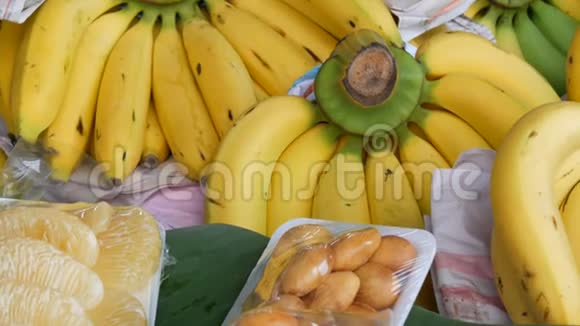泰国街头市场柜台上漂亮的黄色小香蕉和其他异国水果视频的预览图