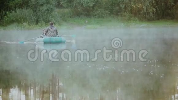 两人在森林湖的橡皮船上钓鱼美丽的早晨景观黎明和雾在水面上视频的预览图