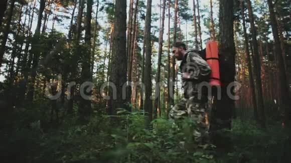 年轻的妈妈穿着工作服背着背包独自穿过森林旅游男性在大自然中度过闲暇时间视频的预览图