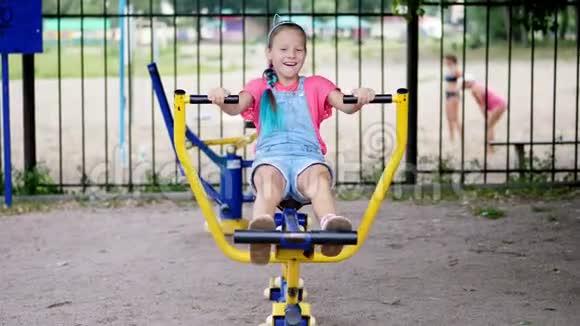 微笑着快乐的八岁女孩订婚了在户外运动设备上做运动在公园里夏天视频的预览图