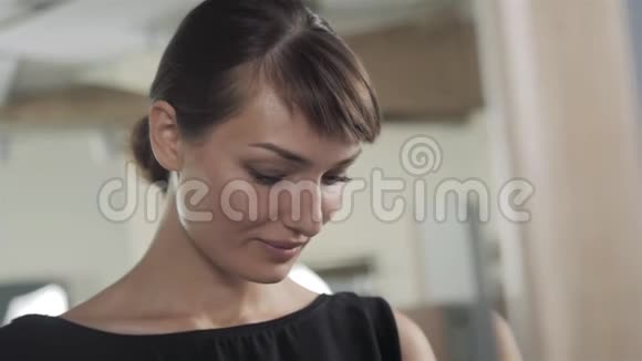 一个美容院的女人用台灯支票发型和化妆来照镜子视频的预览图
