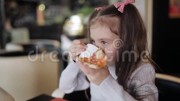 一个小女孩在吃一块带有拉伸奶酪的披萨视频的预览图