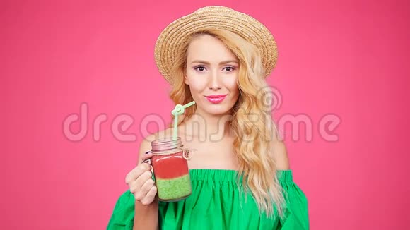 年轻女子手里拿着一个杯子上面有粉色背景的冰沙视频的预览图