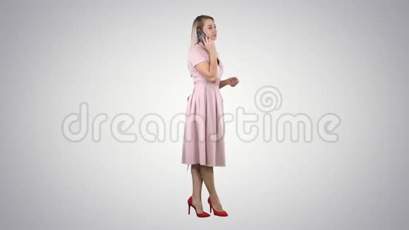 穿粉色裙子的漂亮女孩在电话里的渐变背景视频的预览图
