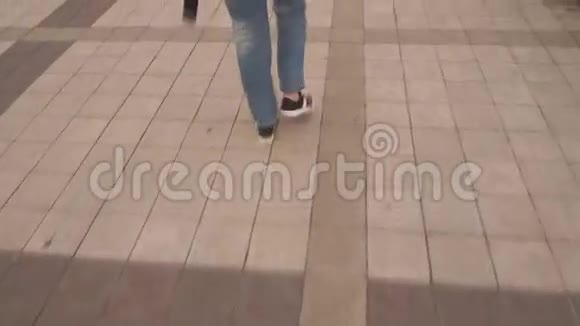 穿牛仔裤的腿女孩在去公园的路上视频的预览图