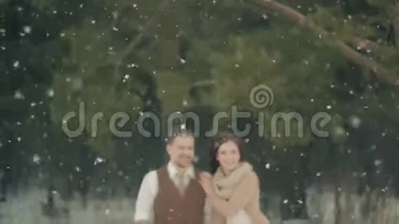 在冬天的圣诞大雪中一对爱侣走着视频的预览图