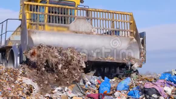 在一辆垃圾车附近的垃圾填埋场卡车上近距离观看视频的预览图