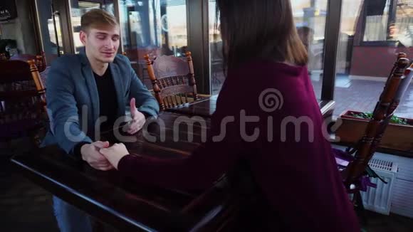 一对夫妇坐在午餐会上手牵着手讨论着女孩的新工作地点视频的预览图