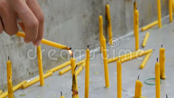 薄黄蜡烛用火焰点燃另一支蜡烛许多薄黄蜡烛视频的预览图