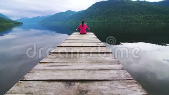 一个穿红色夹克的女孩正在码头上放松视频的预览图
