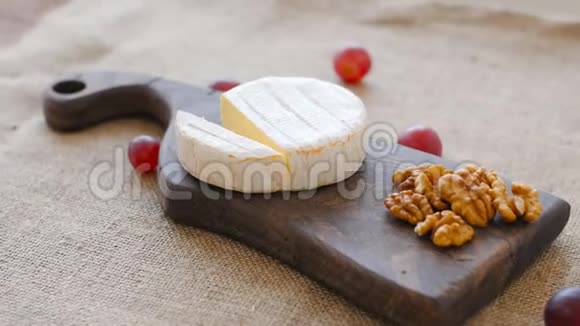 白色霉菌奶酪在木切割板上旋转视频的预览图