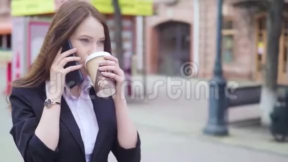 多莉拍摄的吸引人的混合种族商务女性谈话智能手机和喝咖啡和喝咖啡视频的预览图