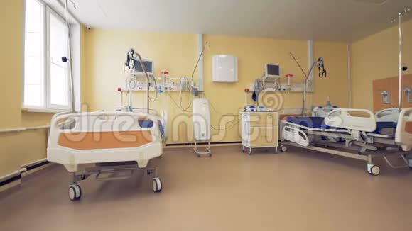 配有两张轮式床和医疗库存的设备齐全的医院病房视频的预览图