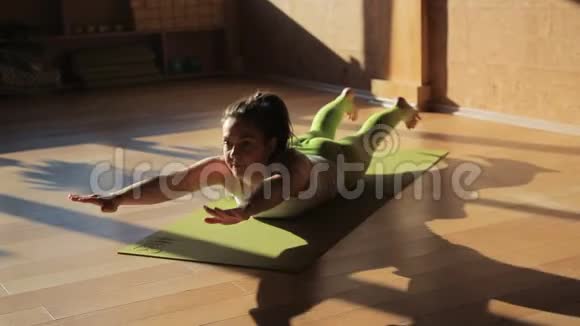 女私人教练在运动垫上躺着做体式运动视频的预览图